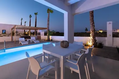 a patio with a table and chairs next to a swimming pool at Villa Salty Sun 1 in Kremasti
