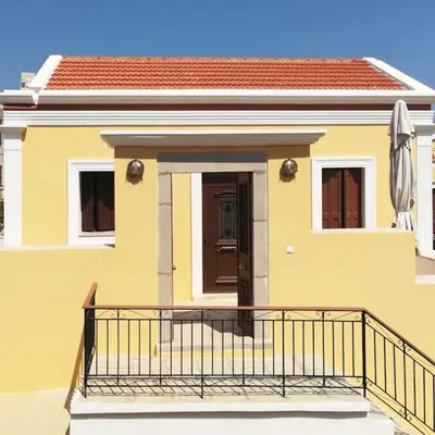 a yellow house with a balcony in front of it at Villa Elizabeth in Symi