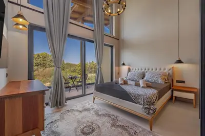 a bedroom with a bed and a large window at Olympus Luxury Villa Rhodes in Koskinou