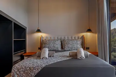 a bedroom with a large bed with two pillows at Olympus Luxury Villa Rhodes in Koskinou