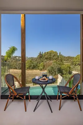 a table and two chairs on a balcony with a view at Olympus Luxury Villa Rhodes in Koskinou