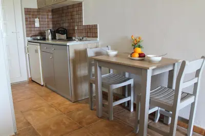 a kitchen with a table with a bowl of fruit on it at Melody Studios Faliraki in Faliraki