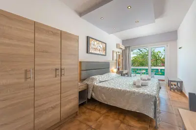 a bedroom with a bed and a table in a room at Melody Studios Faliraki in Faliraki
