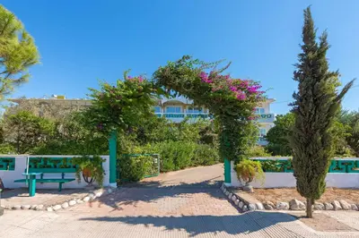 a garden with a bench and flowers in front of a building at Melody Studios Faliraki in Faliraki