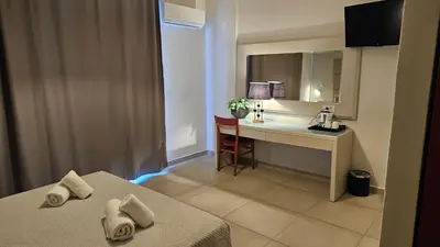 a room with a desk and a bed with towels at Atlantis Boutique ΑΝΝΕX in Rhodes Town