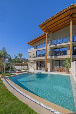 a villa with a swimming pool in front of a house at Vadis Luxury Villa Rhodes in Koskinou