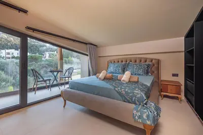 a bedroom with a bed and a large window at Vadis Luxury Villa Rhodes in Koskinou