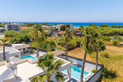 an aerial view of a resort with a pool and palm trees at Villa Palm Vista by Villa Plus in Kremasti