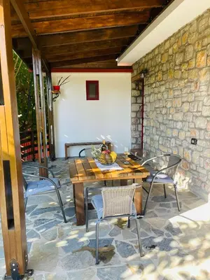 a patio with a table and chairs and a stone wall at Thomas house in Archangelos