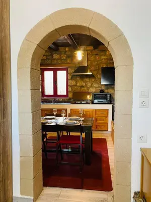 an archway in a kitchen with a table with chairs at Thomas house in Archangelos