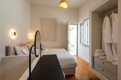 a bedroom with a bed and a dresser and a mirror at Tinas Lindian Serenity Villa in Líndos