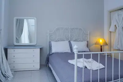 a bedroom with a bed with a mirror and a dresser at Villa Skiadeni in Halki