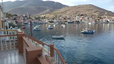 a group of boats in the water near a city at Villa Skiadeni in Halki
