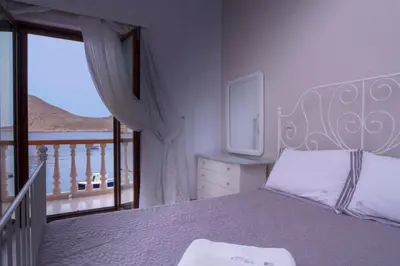a bedroom with a large bed and a balcony at Villa Skiadeni in Halki
