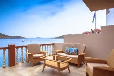 a balcony with chairs and a table and a view of the ocean at Villa Skiadeni in Halki