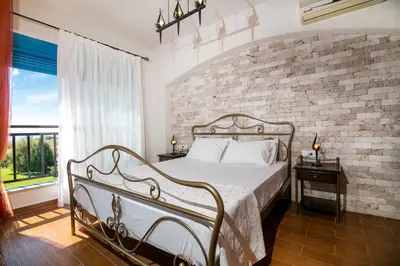 a bedroom with a bed and a brick wall at Seascape Villa in Afantou