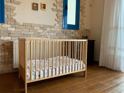 a crib in a room with a brick wall at Seascape Villa in Afantou