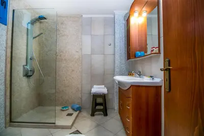 a bathroom with a shower and a sink and a glass shower backdoor at Seascape Villa in Afantou