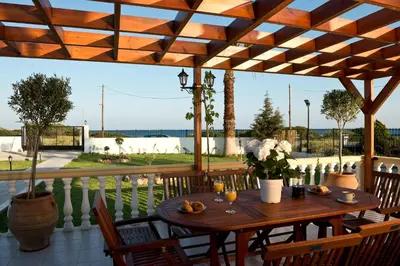 a wooden table and chairs on a patio with a view at Villa Nefeli in Kiotari
