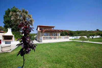 a house with a green yard with a building at Villa Nefeli in Kiotari