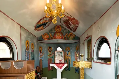 a church with a chandelier and paintings on the walls at Villa Nefeli in Kiotari