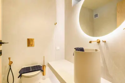 a bathroom with a sink and a toilet and a mirror at Villa Pefkos Cove by Villa Plus in Pefki Rhodes