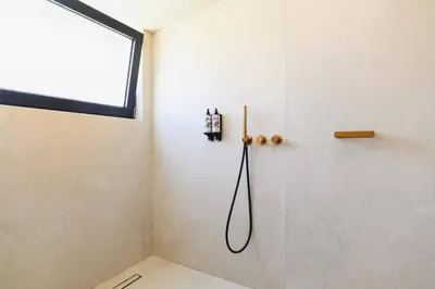 a shower in a bathroom with a window at Villa Pefkos Cove by Villa Plus in Pefki Rhodes