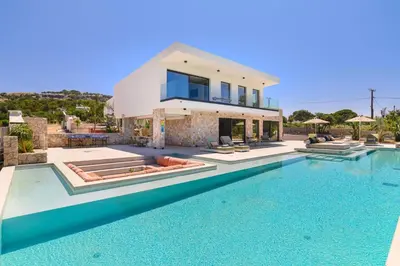a villa with a swimming pool in front of a house at Villa Pefkos Cove by Villa Plus in Pefki Rhodes