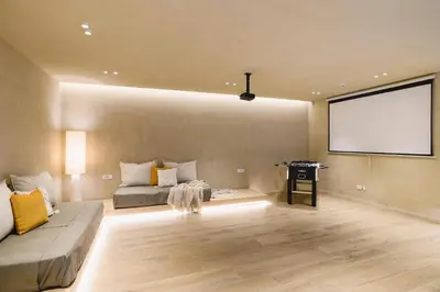 a living room with a couch and a projection screen at Villa Pefkos Cove by Villa Plus in Pefki Rhodes