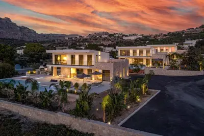 an aerial view of a house with a sunset at Villa Pefkos Cove by Villa Plus in Pefki Rhodes