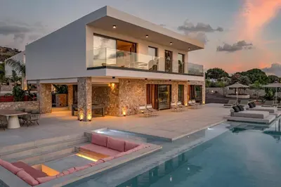 a house with a swimming pool in front of it at Villa Pefkos Shore by Villa Plus in Pefki Rhodes