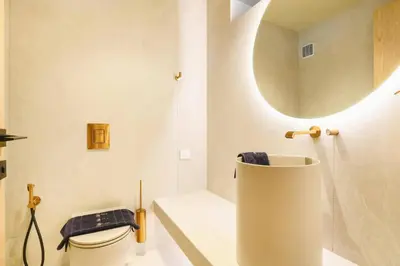 a bathroom with a toilet and a sink and a mirror at Villa Pefkos Shore by Villa Plus in Pefki Rhodes