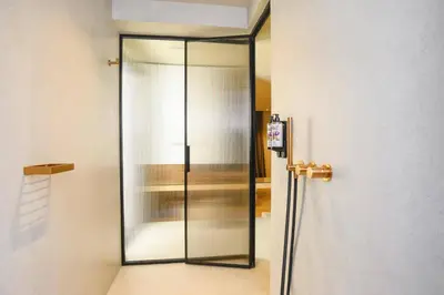 a glass door in a room next to a wall at Villa Pefkos Shore by Villa Plus in Pefki Rhodes