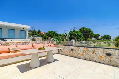 a patio with a bench and a stone wall at Villa Pefkos Shore by Villa Plus in Pefki Rhodes