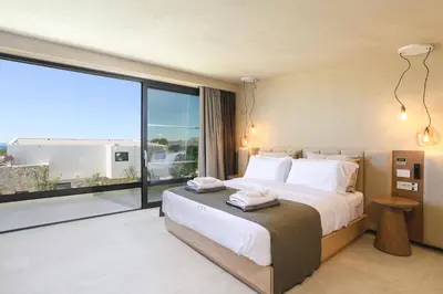 a bedroom with a large bed and a large window at Villa Pefkos Sunset by Villa Plus in Pefki Rhodes