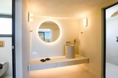 a bathroom with a round mirror and a sink at Villa Pefkos Sunset by Villa Plus in Pefki Rhodes