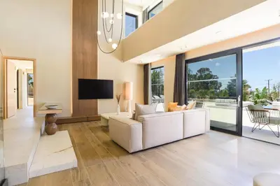a living room with a white couch and a tv at Villa Pefkos Sunset by Villa Plus in Pefki Rhodes