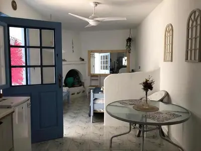 a kitchen and living room with a glass table and a room at Studio Lachania in Lachania