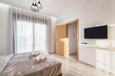 a white bedroom with a bed with towels on it at Ramo Luxury Villa in Kremasti