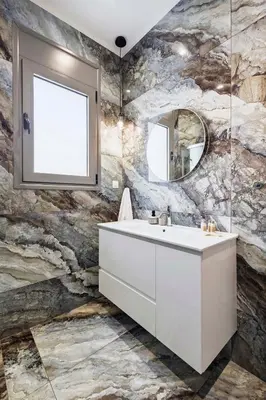 a bathroom with a white sink and a stone wall at Ramo Luxury Villa in Kremasti