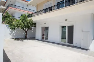 a white building with a tree in the courtyard at Rhodes Center 2-Bedroom Apartment in Rhodes Town
