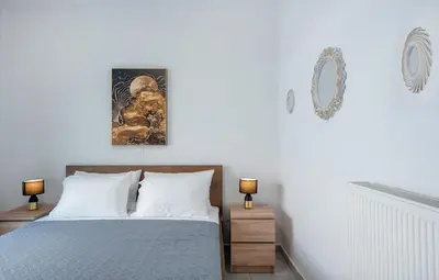 a bedroom with a bed with two lamps and a picture on the wall at Rhodes Center 2-Bedroom Apartment in Rhodes Town