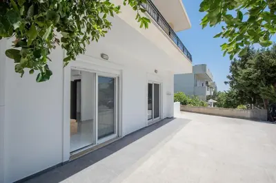 an exterior view of a white house with large windows at Rhodes Center 2-Bedroom Apartment in Rhodes Town