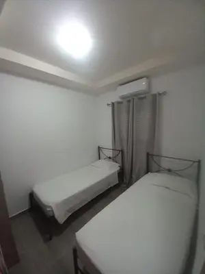 a room with two beds and a light on the ceiling at Damian House in Afantou