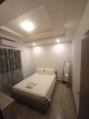 a bedroom with a bed with white sheets and a mirror at Damian House in Afantou