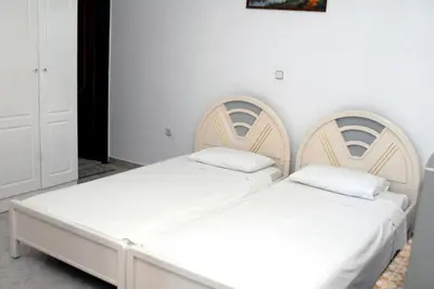 two beds in a bedroom with white walls at Stegnailion in Archangelos