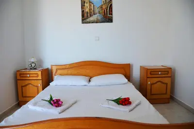 a bedroom with a bed with two towels and flowers on it at Stegnailion in Archangelos