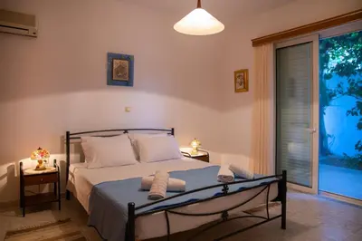 a bedroom with a bed and a large window at Stegnailion in Archangelos