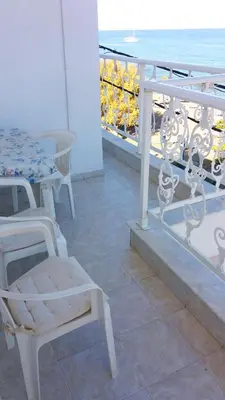 a balcony with a table and chairs and the ocean at Stegnailion in Archangelos