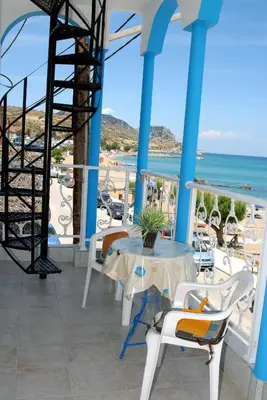a balcony with a table and chairs and the ocean at Stegnailion in Archangelos